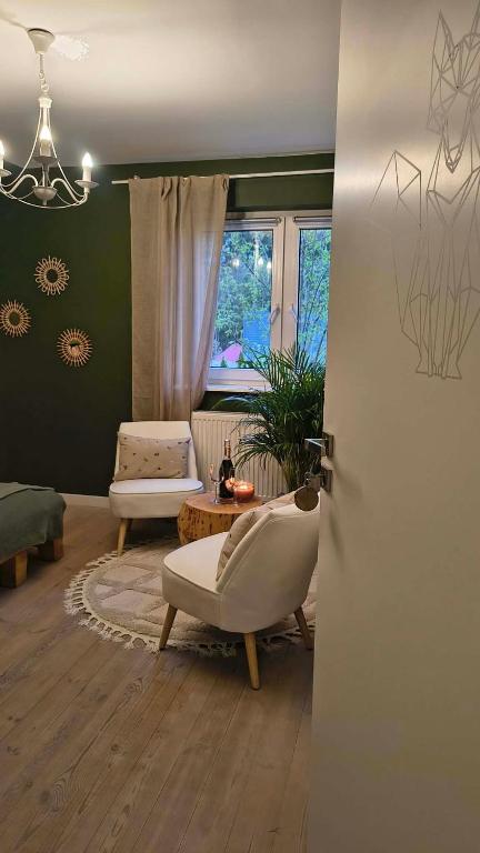 a living room with a couch and a chair at Leśna Kryjówka in Trzebciny