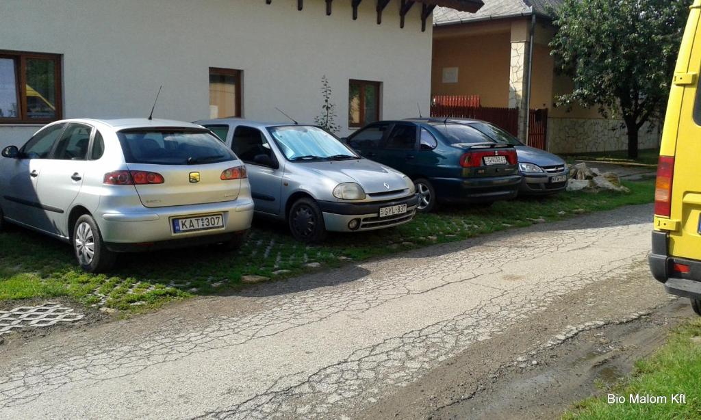 un groupe de voitures garées à côté d'une maison dans l'établissement Júlia Vendégház, à Tar