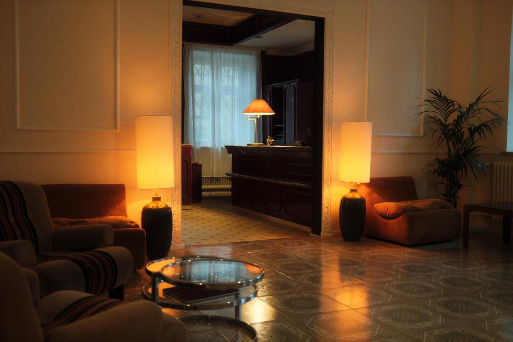 een woonkamer met twee stoelen en een spiegel bij Hotel DEDE in Augsburg