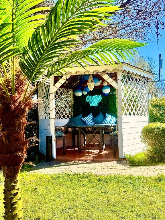 a gazebo with a table and a palm tree at CUBA domki letniskowe in Sarbinowo