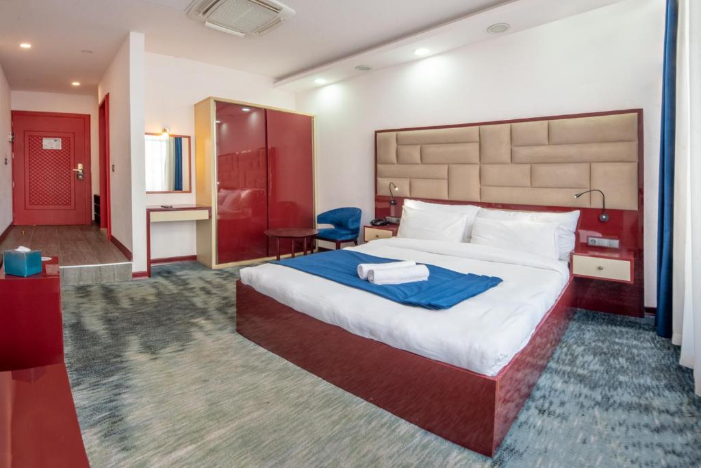 a hotel room with a large bed and a bathroom at Denis Hotel Tbilisi in Tbilisi City