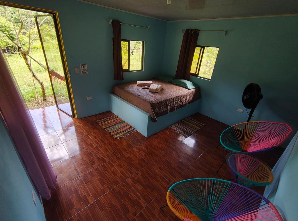 a bedroom with a bed and two chairs in a room at Finca Paz y Flora in Drake