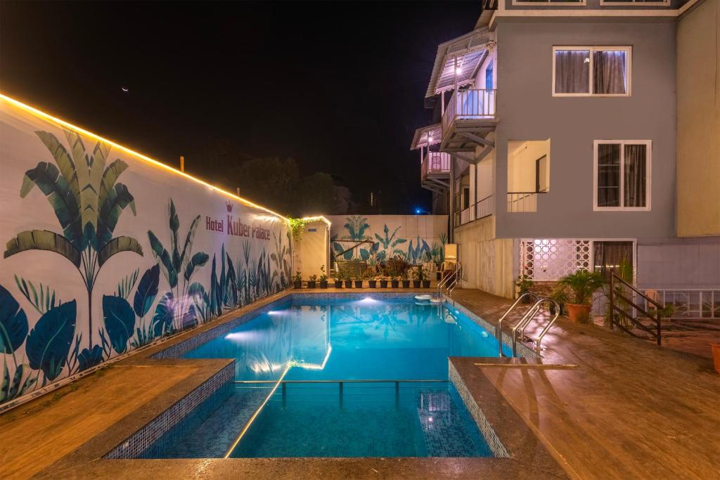 a swimming pool in front of a building at night at Treebo Kuber Palace with Swimming Pool in Mahabaleshwar