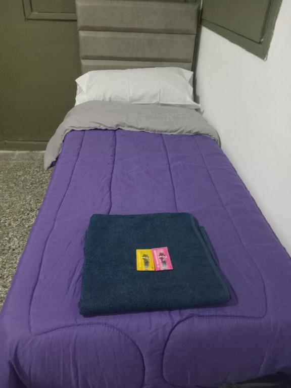a bed with a purple blanket on top of it at SB hostel in La Rioja