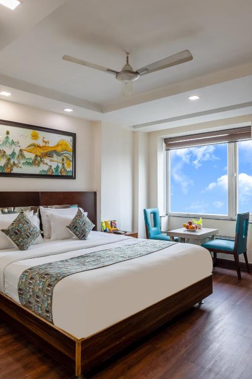 a bedroom with a large bed and a table and chairs at Hotel Neu Villa, City Centre - Near Connaught Place & NDLS Station in New Delhi