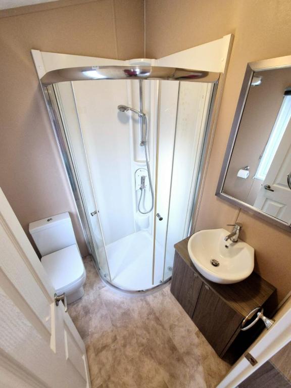 a bathroom with a shower and a toilet and a sink at Birchington Vale - Delta Lodge in Kent