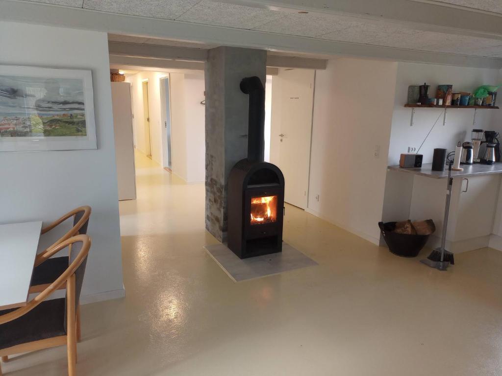 a living room with a wood stove in a room at Sønderhedens B&B in Vrå