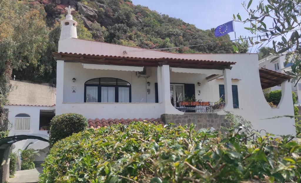 a white house with a mountain in the background at CAPERCIA home in Forio d'Ischia