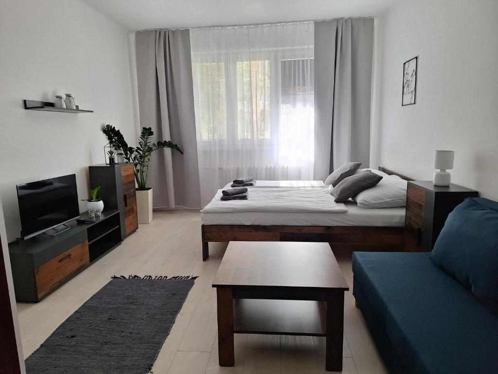 a living room with a bed and a couch at ApartmanONE in Hlohovec