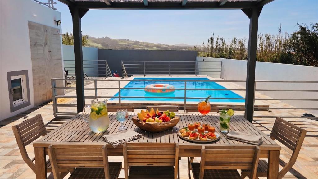 a table with fruit on it next to a pool at Blue Lagoon Villa in Achada