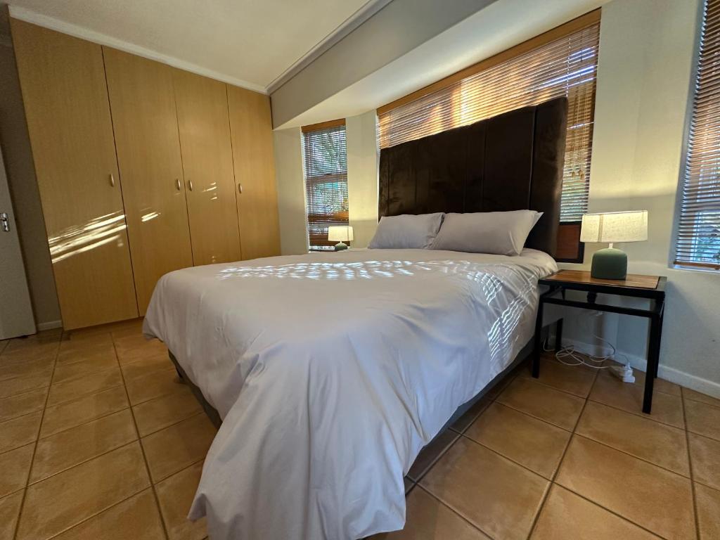 a bedroom with a large white bed and a table at Cute Pool Side Apartment in Monte Vista
