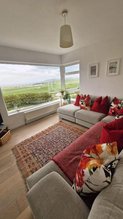a living room with two couches and a large window at Ocean Heights House in Dunfanaghy
