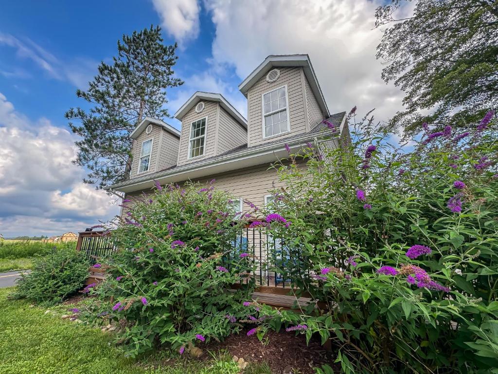 a house with purple flowers in the yard at New: Charming and Cozy Great Value in Swanton