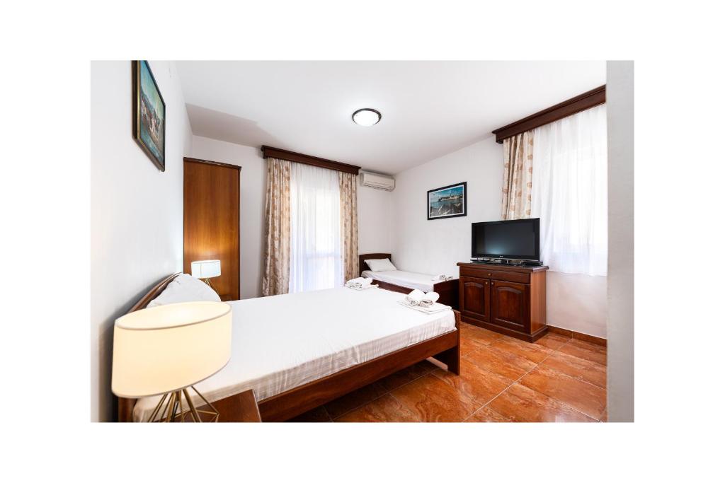 a hotel room with a bed and a television at Villa MD in Budva