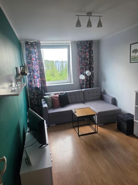 a living room with a couch and a window at Siódme niebo in Gdańsk
