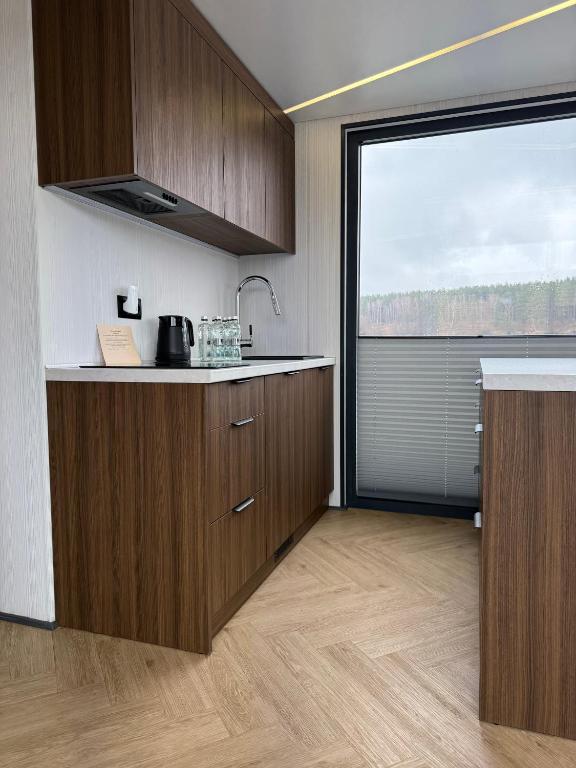 a kitchen with wooden cabinets and a large window at Water House in Puck