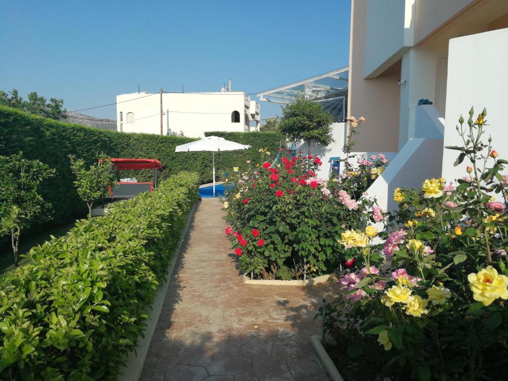 a garden with flowers and an umbrella next to a building at Villa Flash in Eantio