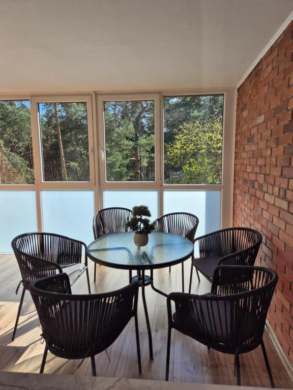 a patio with a table and chairs and windows at MV Apartament in Druskininkai