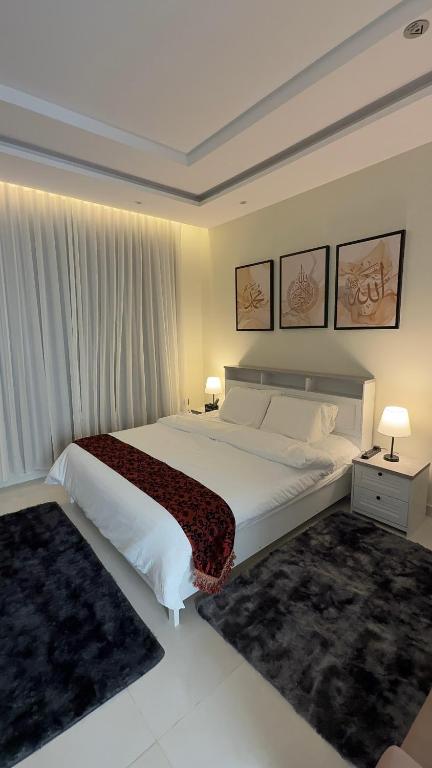 a bedroom with a large white bed and two lamps at دار طيبة in Medina