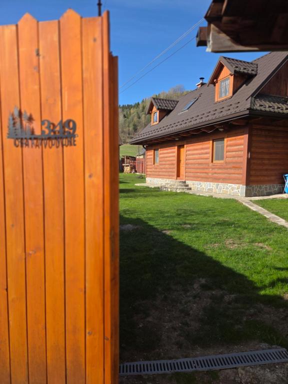 a fence in front of a house with a yard at Chata vo dvore in Osturňa