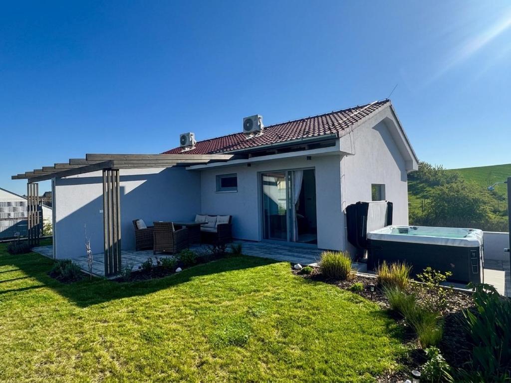 a small white house with a pool in a yard at M&D Appartments in Valtice