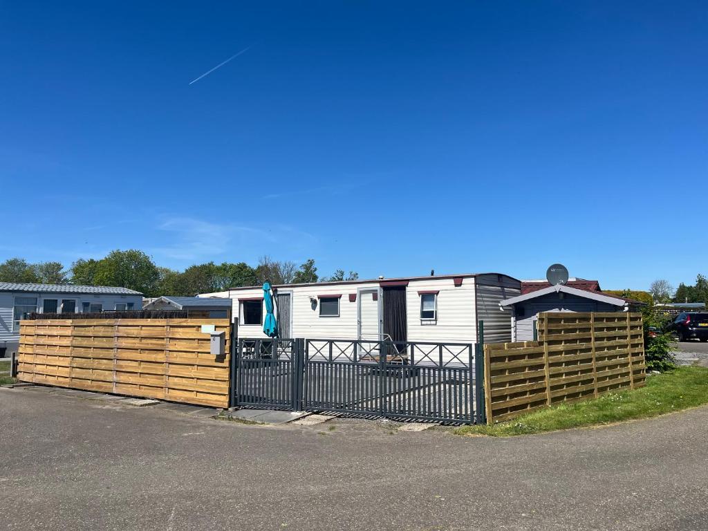an rv is parked behind a wooden fence at het straatje in Scherpenisse