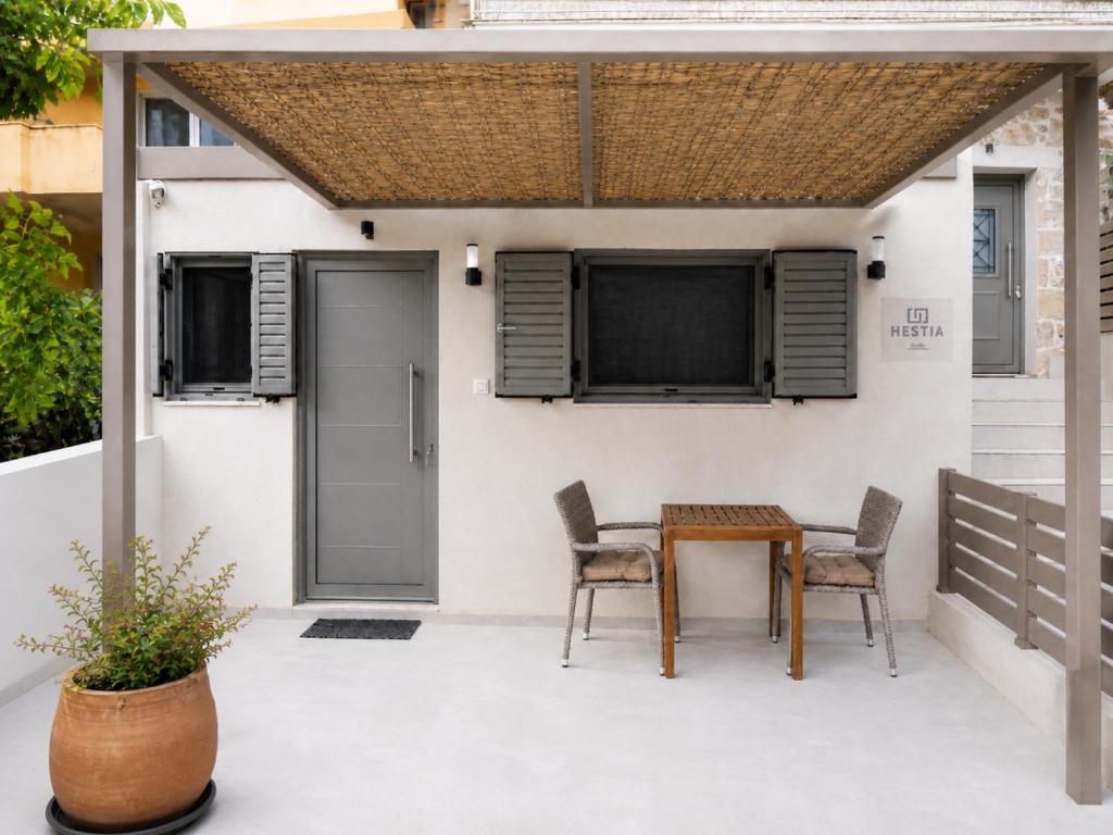 a patio with a wooden table and chairs at HESTIA Studio Georgioupolis in Georgioupolis