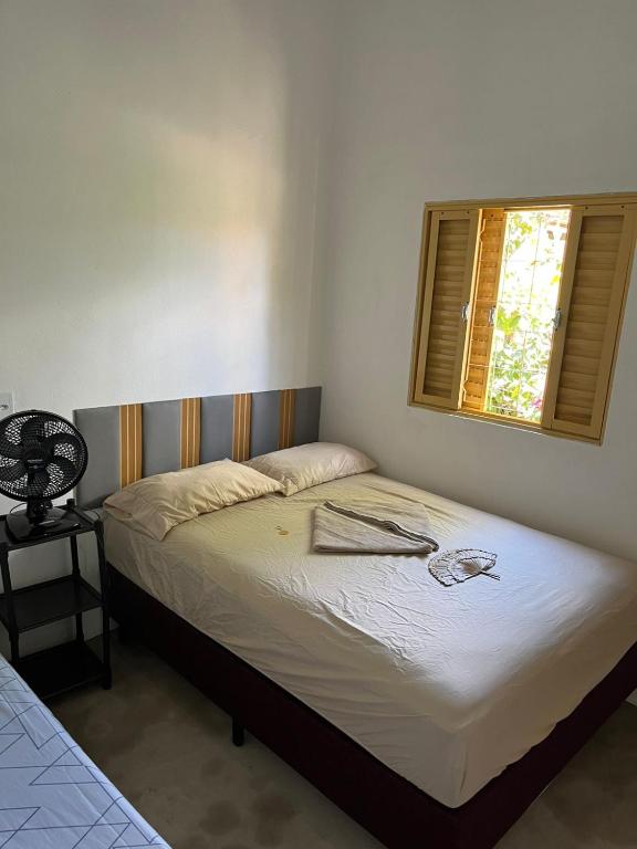 a bed in a bedroom with a window at Cantinho da Naná in Cavalcante