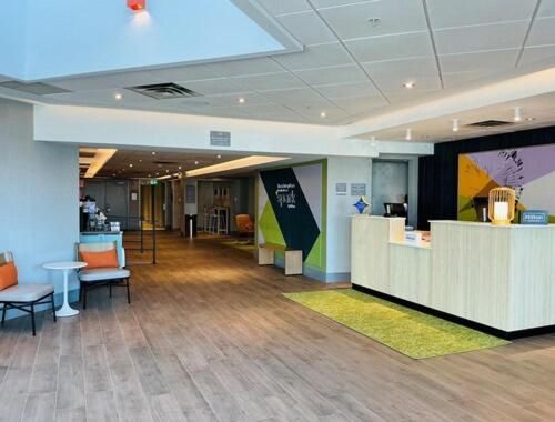 a lobby with chairs and tables in a building at Spark by Hilton Montreal Brossard in Brossard
