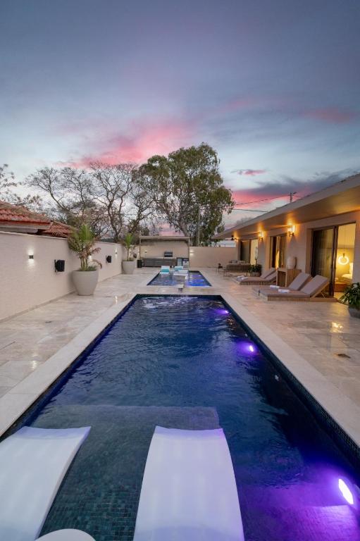 a swimming pool with purple lights in a house at אלאיה סוויטות יוקרה in Shomera
