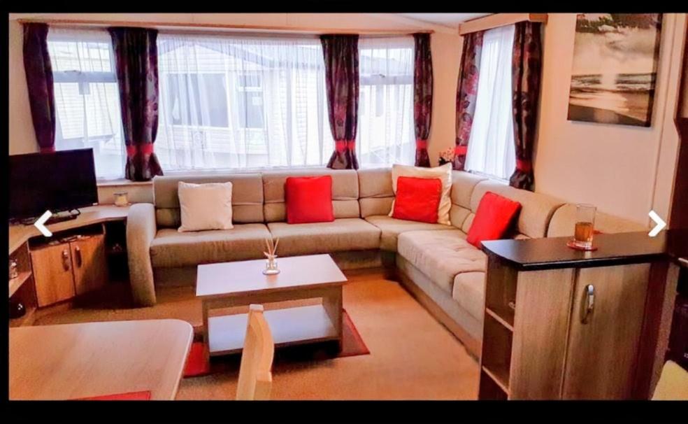 a living room with a couch with red pillows at Jaynes Holiday Caravan Marton Mere in Blackpool