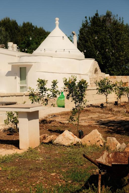 a white building with a green bag in front of it at Trullo Moi in Ostuni