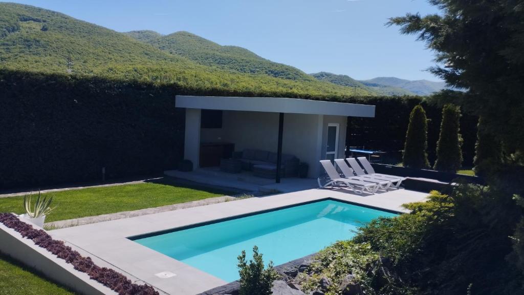 a swimming pool in a yard with two chairs at Vila Gosen in Şard