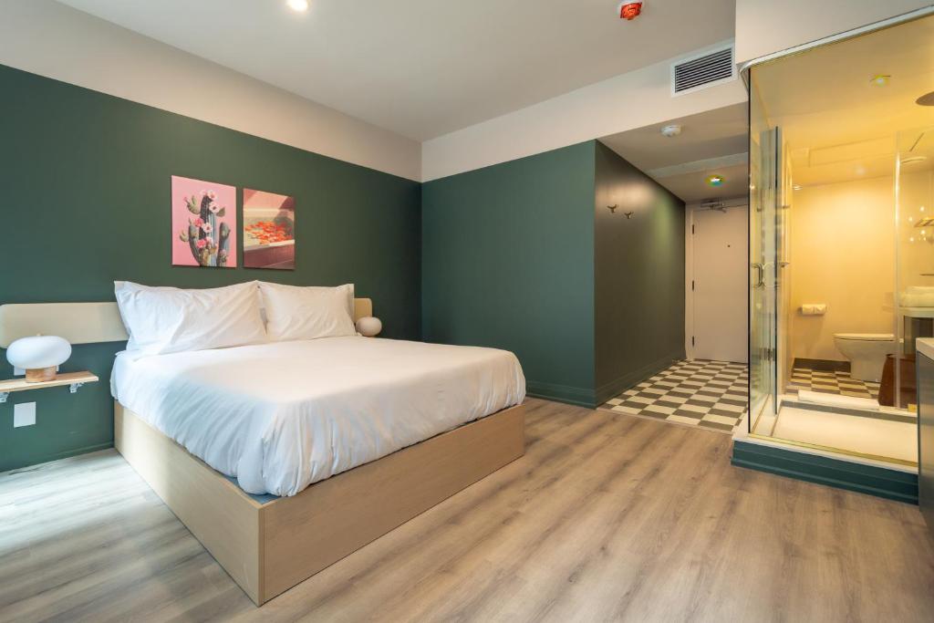 a bedroom with a large bed and a bathroom at Hotel Beebop in Toronto