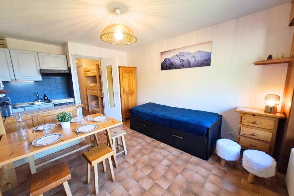 a room with a bed and a table and chairs at Studio at the foot of the ice rink in Le Grand-Bornand
