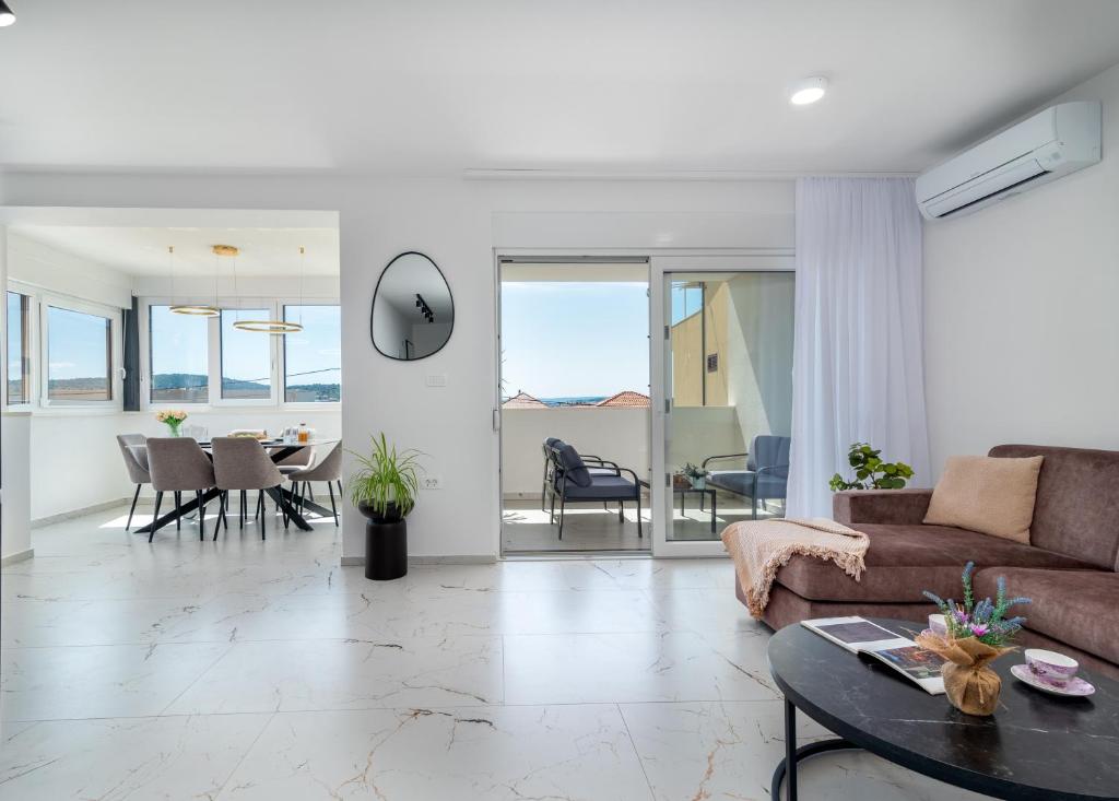 a living room with a couch and a table at Natura Vita Apartment-New Modern Apartment with City View & two Free Parking Spaces-10 min Walk to Trogir Old Town in Trogir