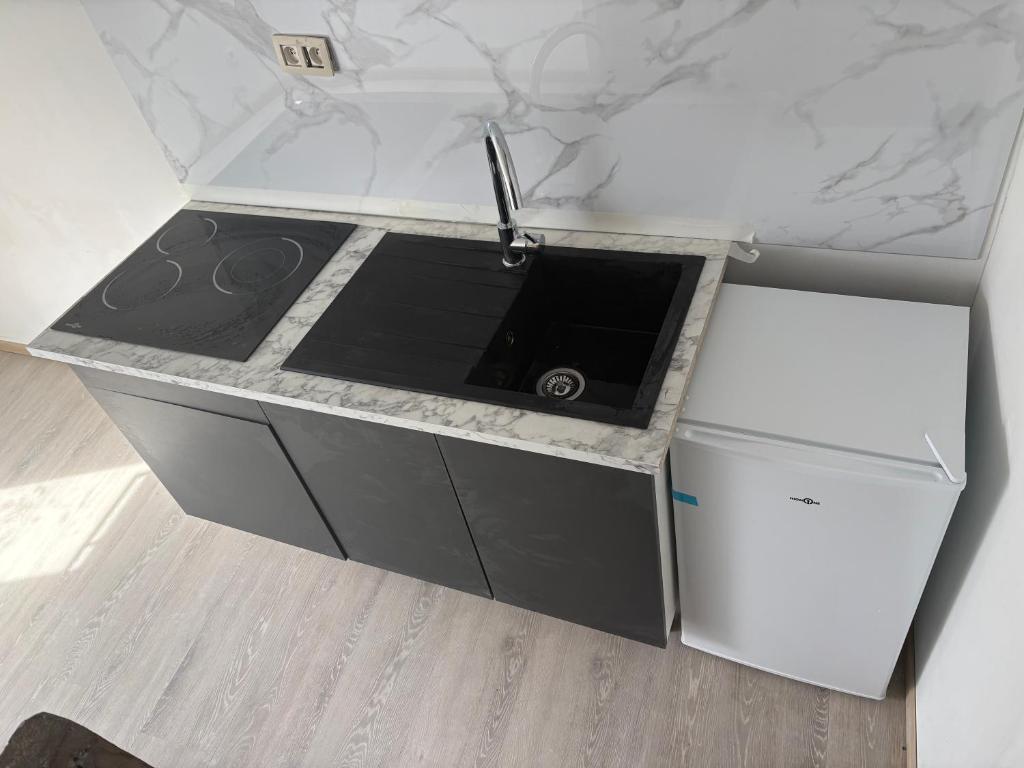 a kitchen counter with a stove and a refrigerator at Studio in Geraardsbergen