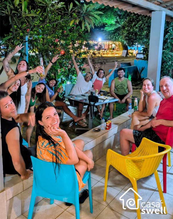 a group of people sitting in chairs at a bar at Casa Swell Hostel in Fernando de Noronha