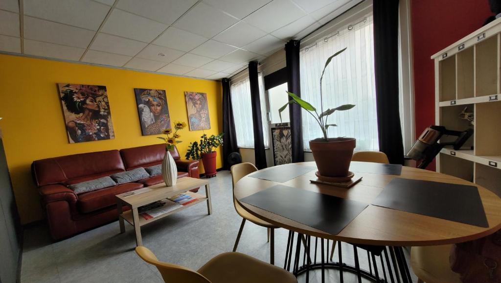 a living room with a table and a couch at Le voyage en couleurs in Issoire
