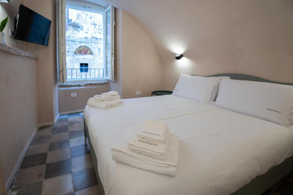 a bedroom with a white bed with towels on it at Borgo Puglia in Bisceglie