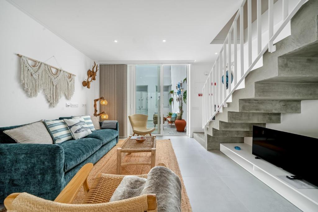 a living room with a blue couch and a staircase at The Blue House - Mediterranean Loft in Faro