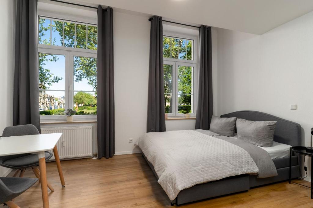 a bedroom with a bed and two windows at Litzi's zentrales Apartment mit Parkplatz in Hockenheim