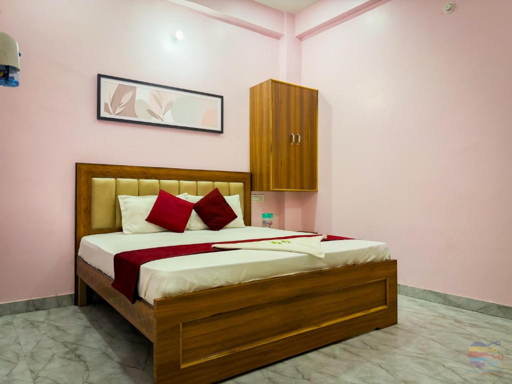 a bedroom with a large bed with red pillows at Hotel Vrinda mohan kunj Near Prem Mandir in Vrindāvan