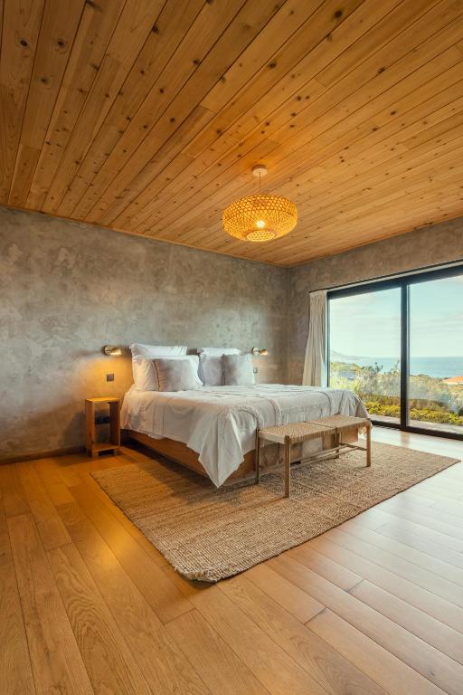 a bedroom with a large bed and a large window at Casa do Alecrim in São Roque do Pico