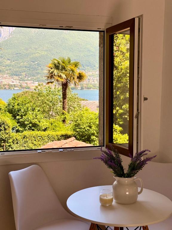 a table and a window with a view of a palm tree at Casetta a Lago in Onno