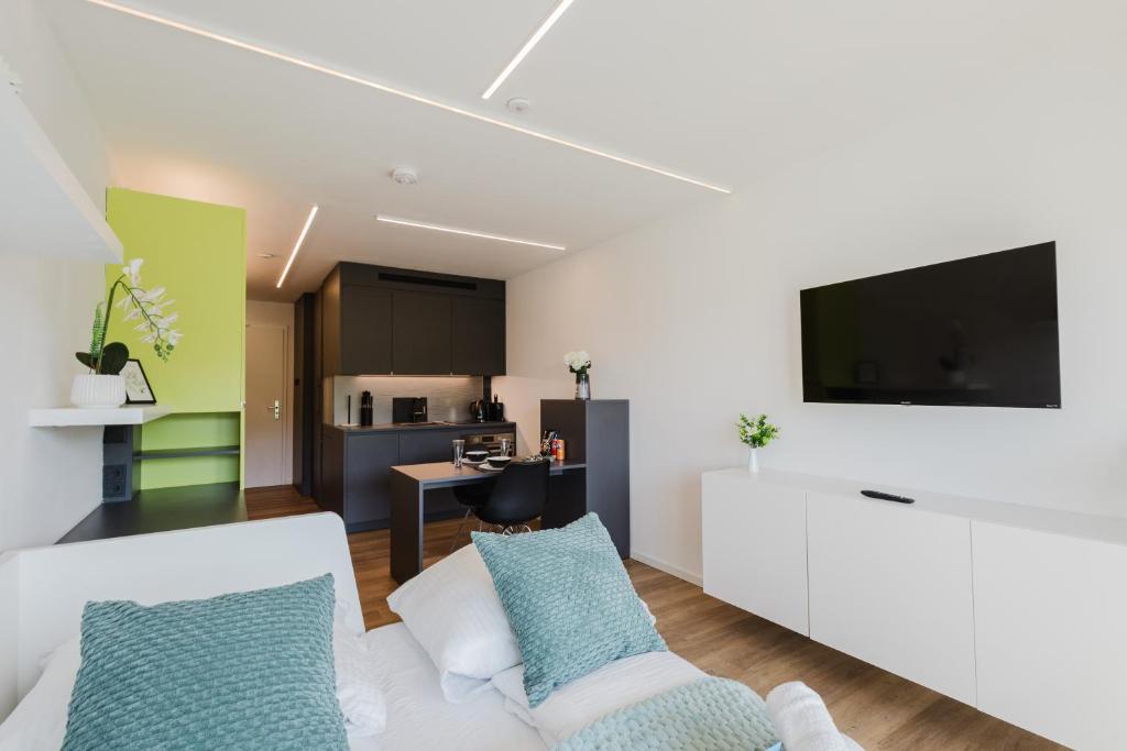 a living room with a white couch and a flat screen tv at Premium Studio mit Balkon - Pfarrkirchen in Pfarrkirchen