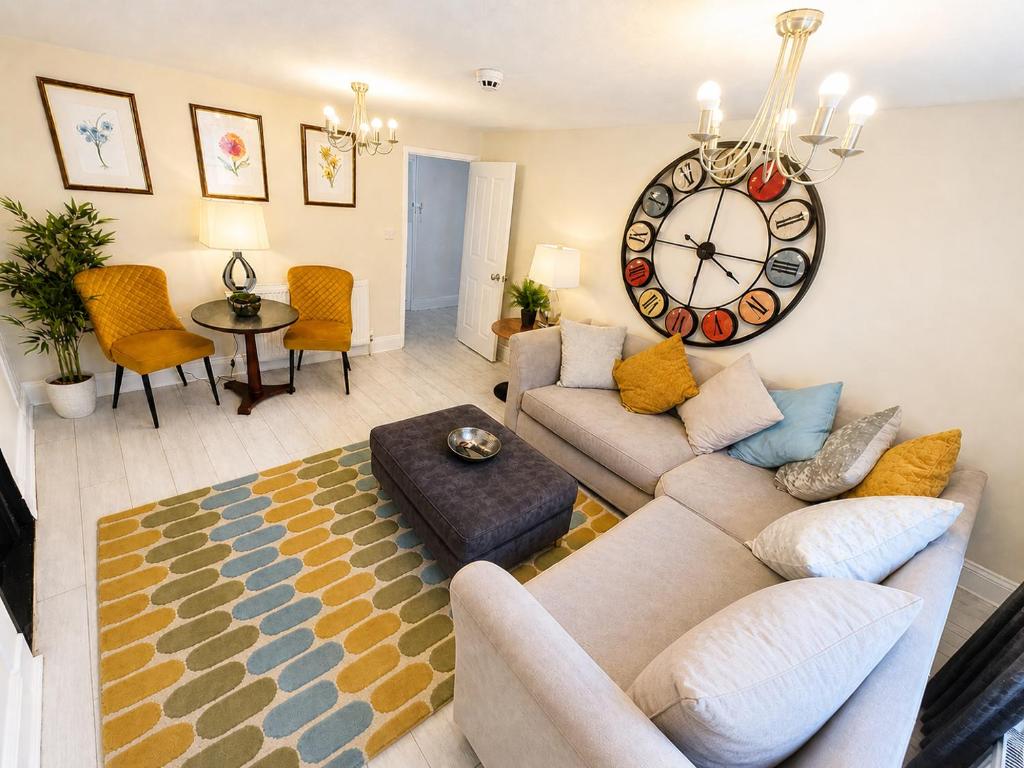 a living room with a couch and a clock on the wall at Hexham Town Centre, Market Place View in Hexham