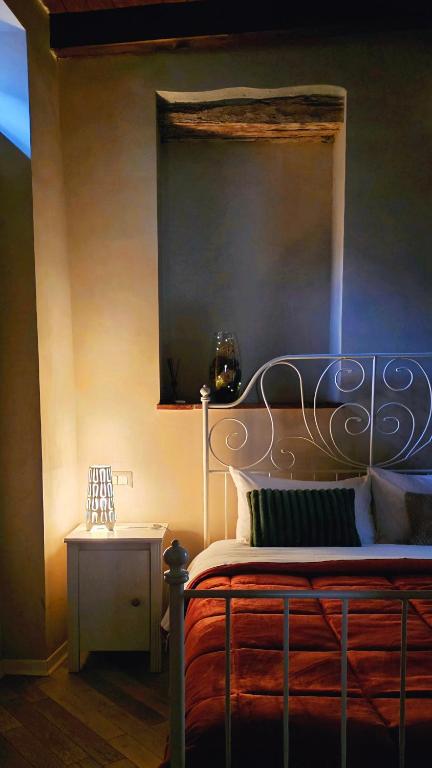 a bedroom with a bed with a metal head board at Le Contrade in Amelia