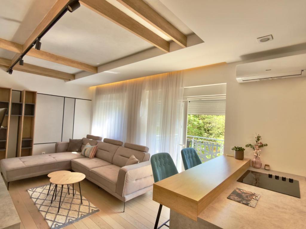 a living room with a couch and a table at Bright Apartment with Balcony near Bus and Train in Mostar