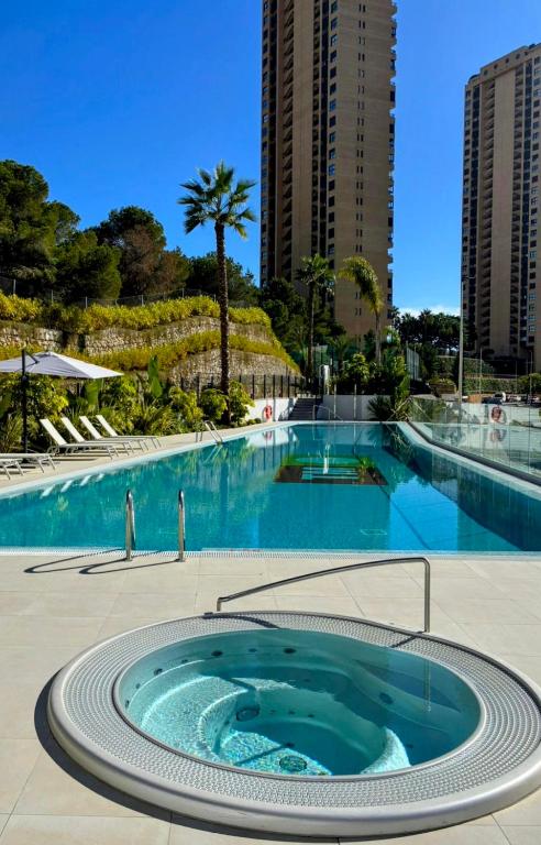 a swimming pool with a hot tub in the middle of a building at Skyline Infinity Apartment Eagle Tower Benidorm in Benidorm